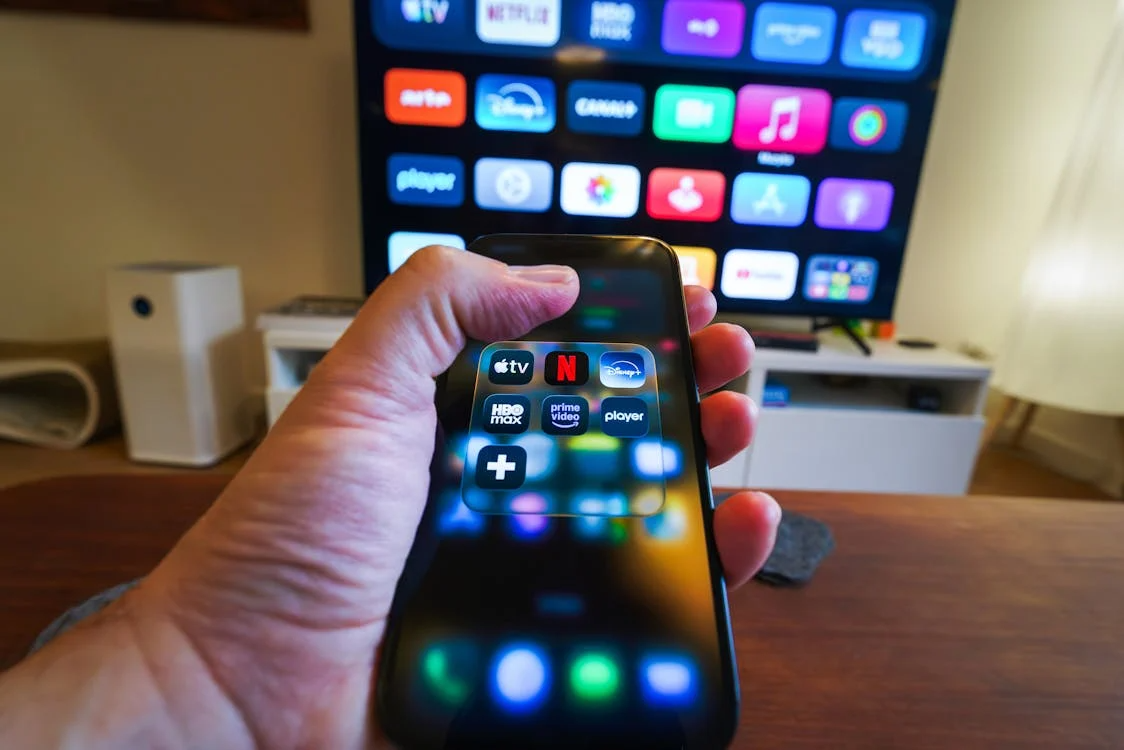 Phone and TV showing multiple apps to illustrate overlapping streaming subscriptions.