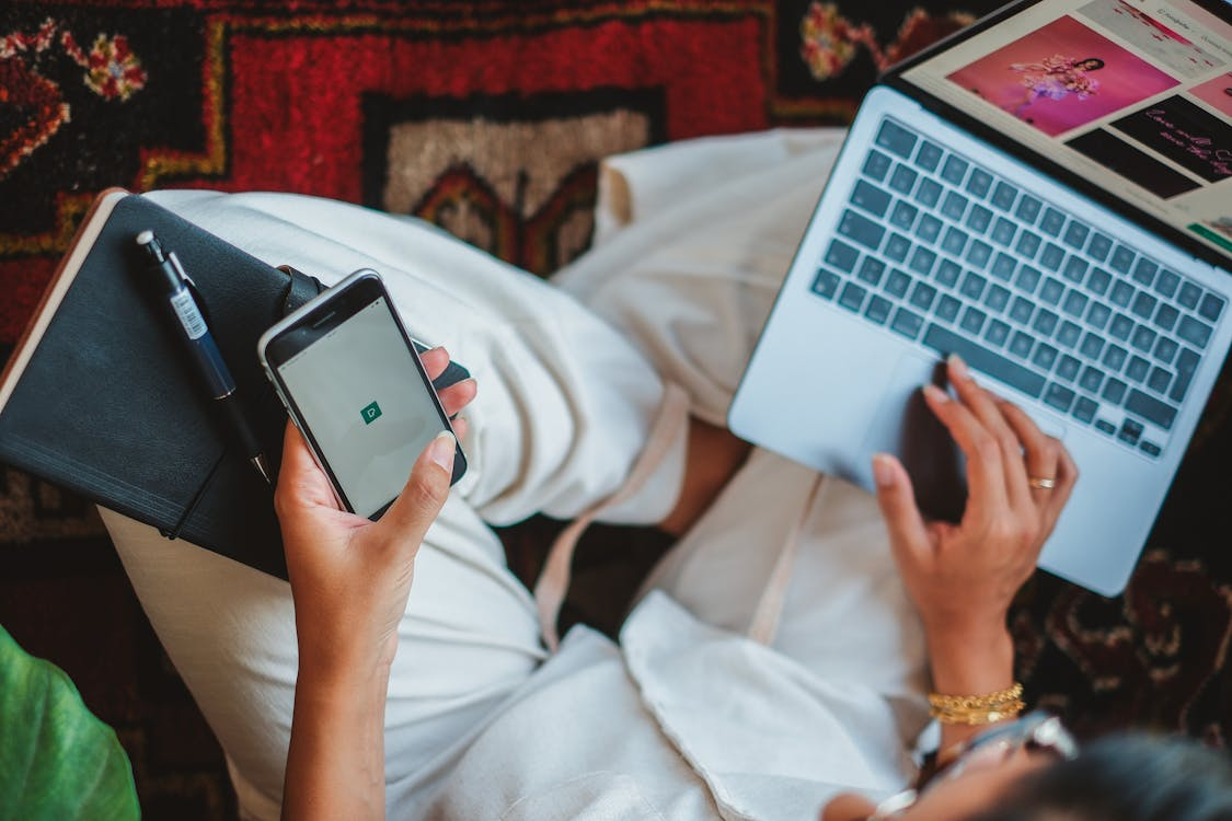 User managing streaming subscriptions on a phone and laptop with streaming hacks to save money.