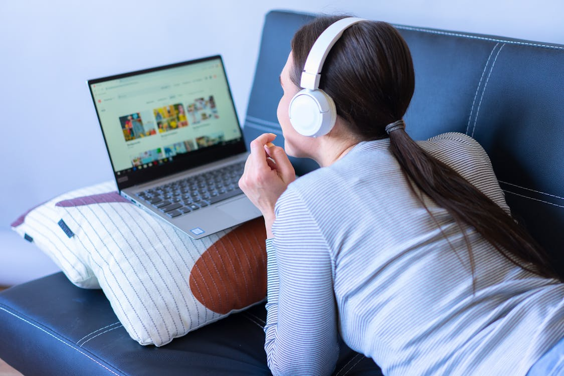 Woman watching free streaming alternatives on a laptop to reduce paid subscriptions.